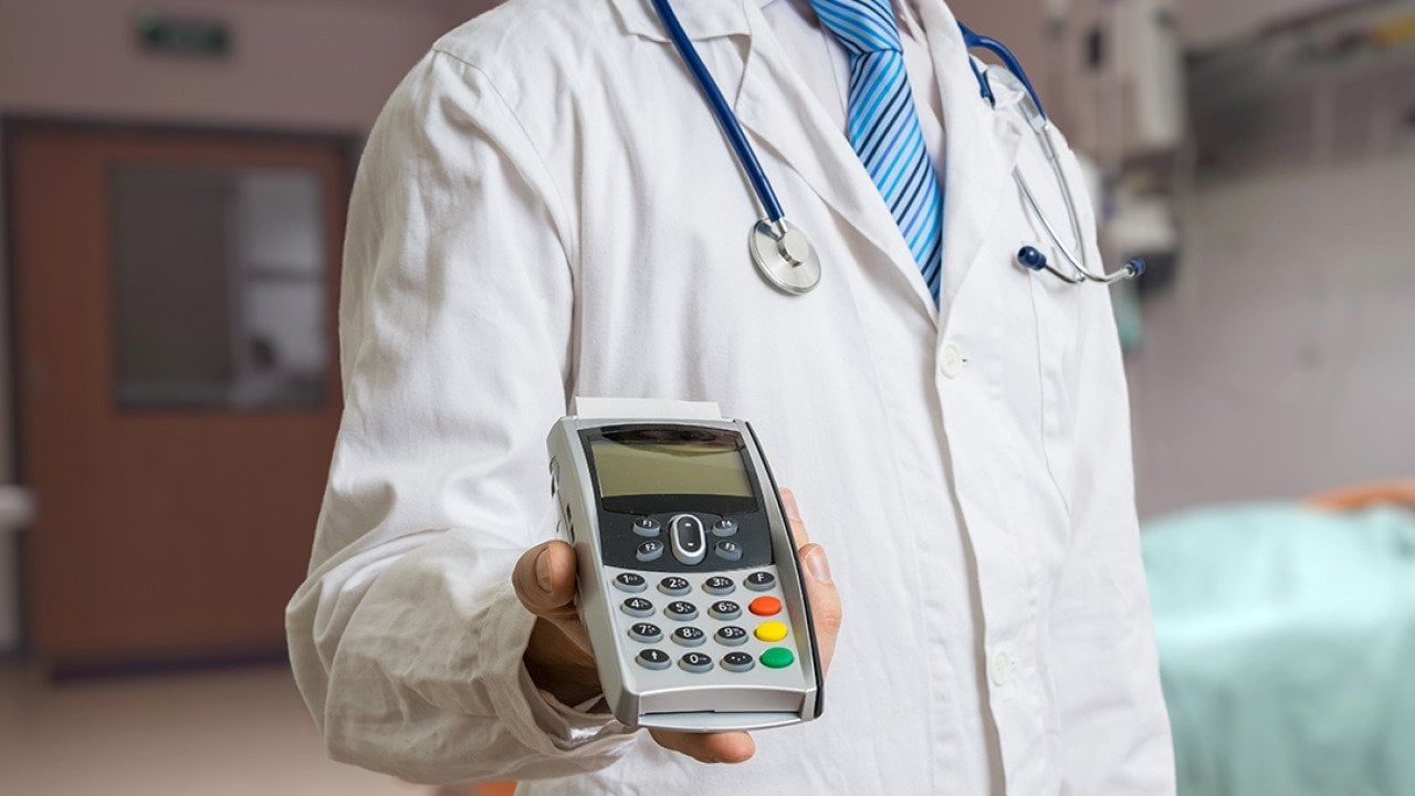 A doctor holding a payment terminal.
