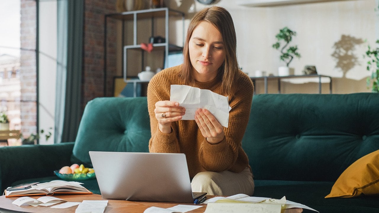 Woman at home looking at receipts.