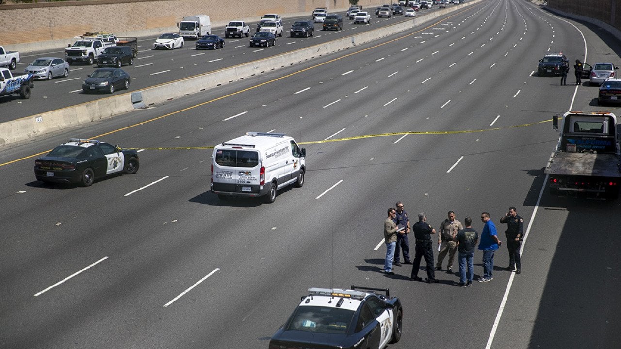 Crime scene investigators gather on the side of California Highway where a 6-year-old boy was fatally shot during a road rage incident on 55 Freeway in Orange.