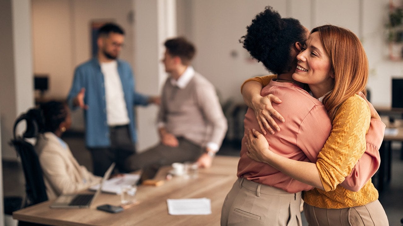 An office worker embracing a colleague. 
