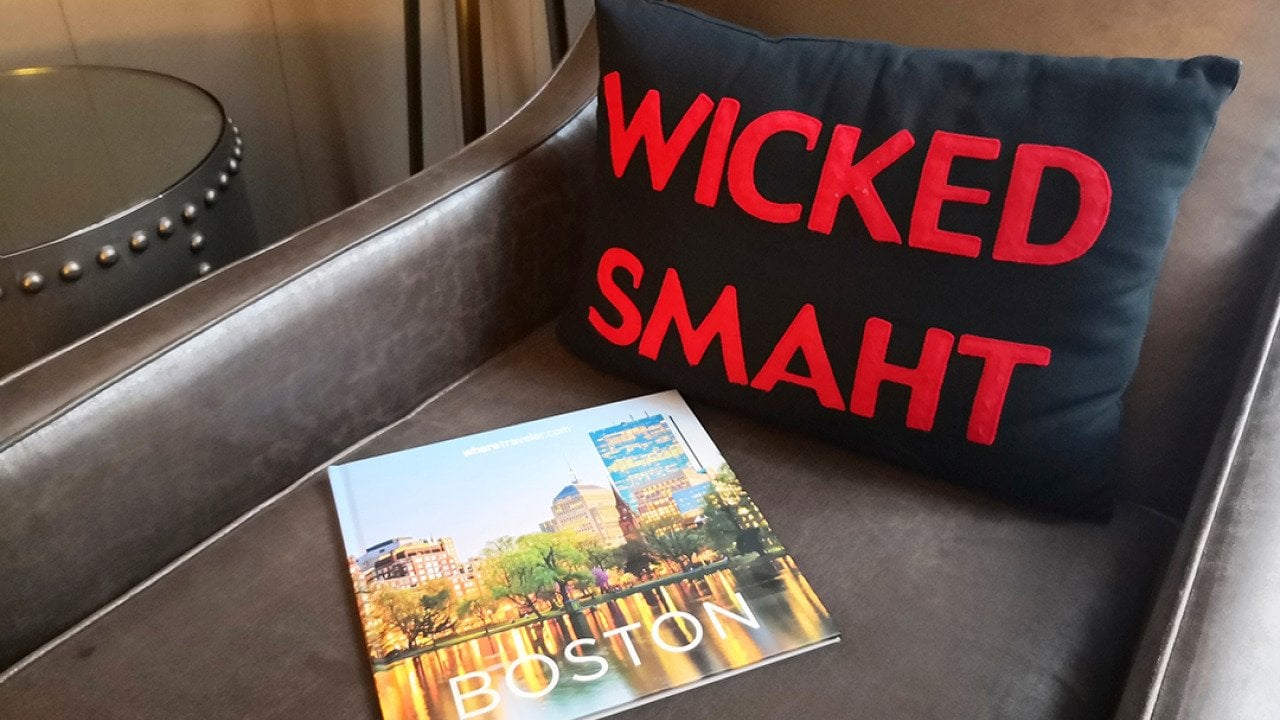 A 'wicked smaht' pillow merchandise beside a travel magazine about Boston, Massachusetts.