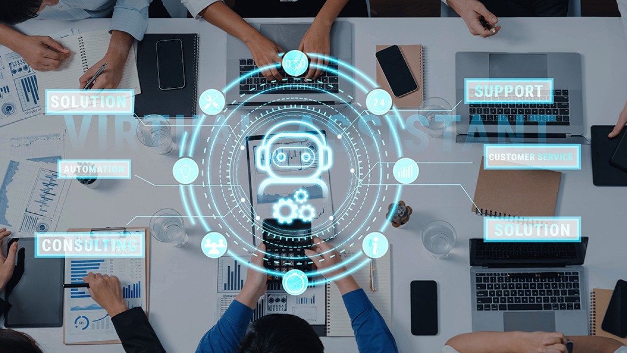 A top view of professionals engaging around a table, while using virtual assistant technology in a meeting.