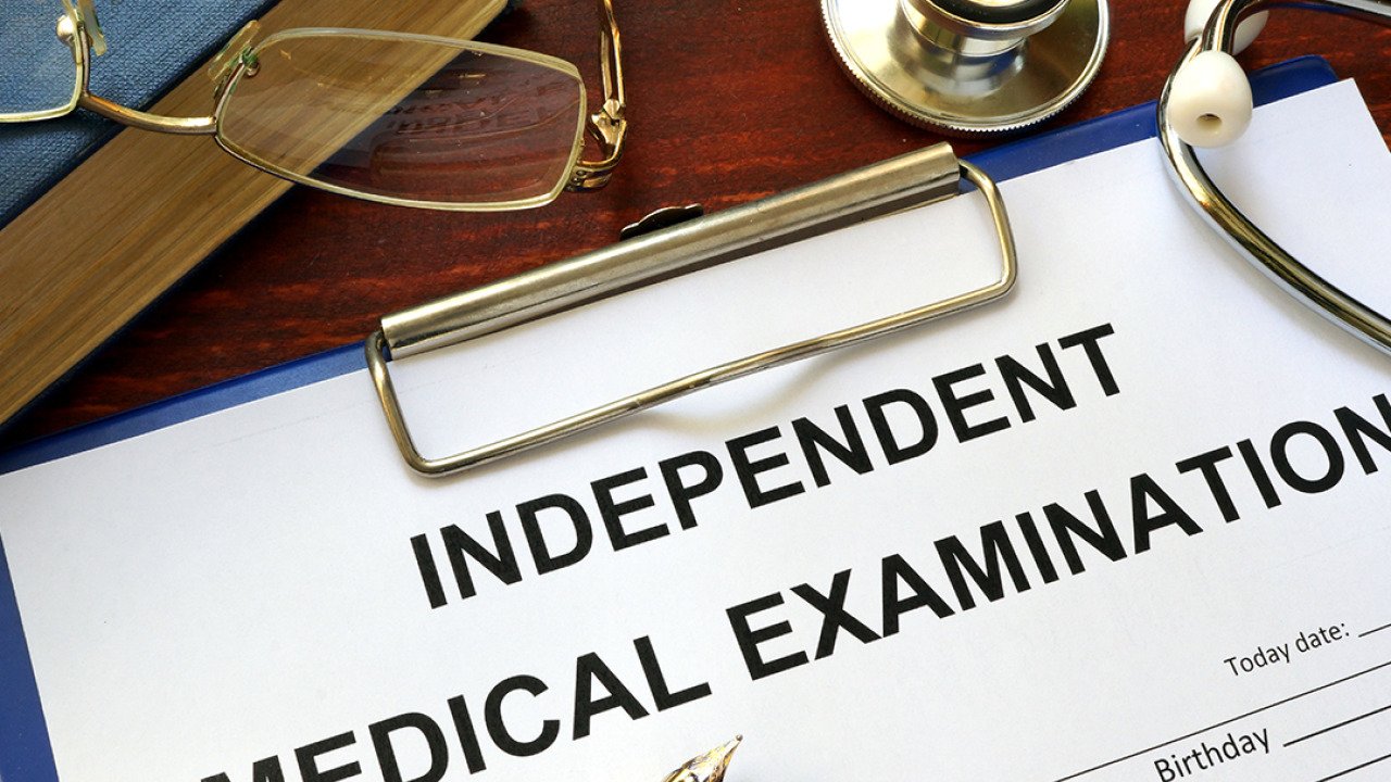 An independent medical examination form on a clipboard.