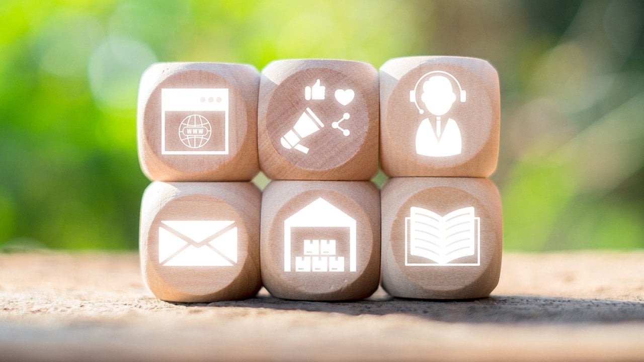 Wooden blocks with icons representing omni channel marketing and communication concepts.