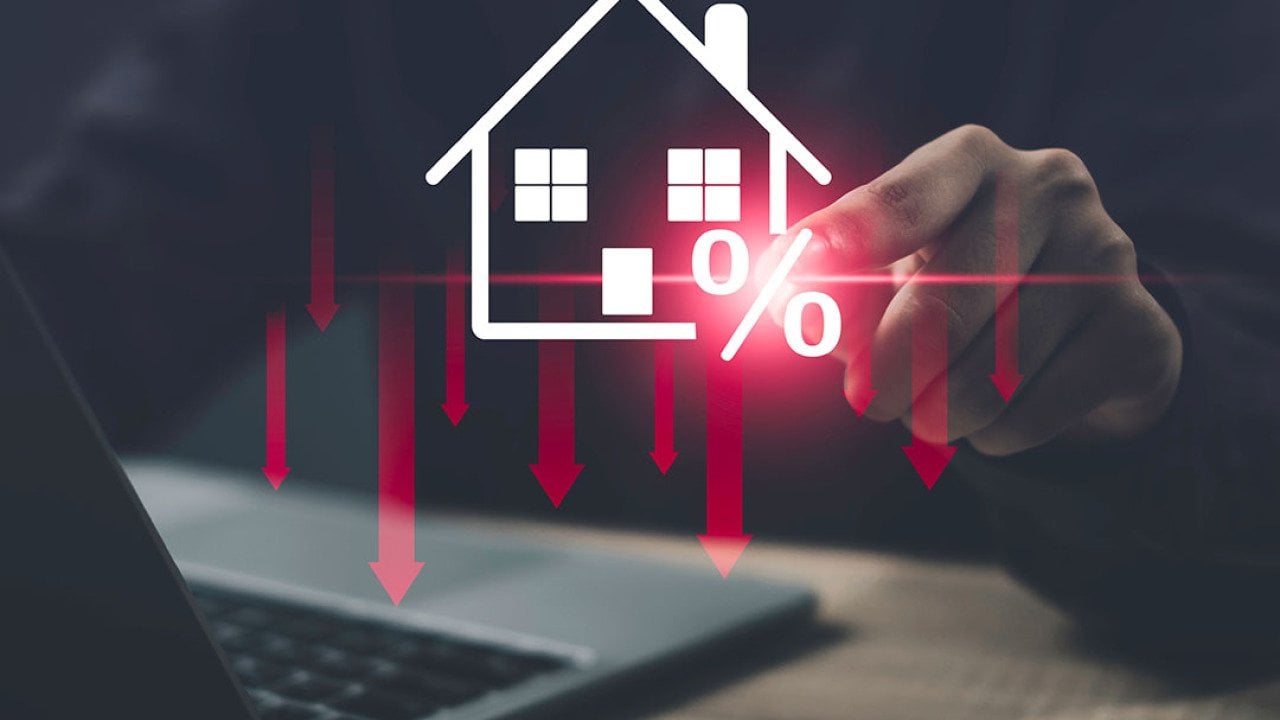 Person using a laptop illustrated with graphics showing concept of lower costs of housing.