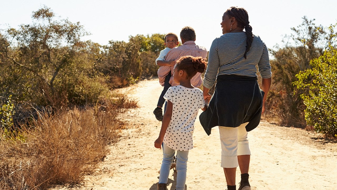 Grandparents walking outdoors with their grandchildren.