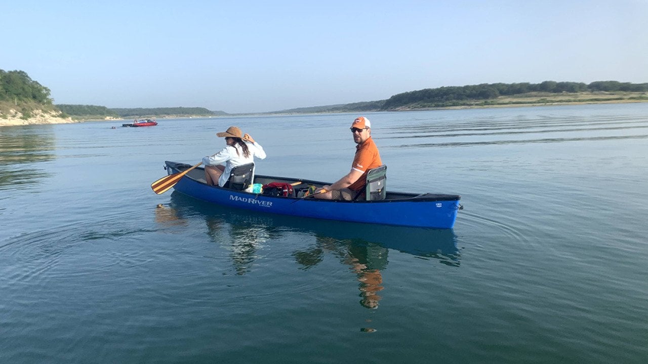 Two people on a boat on a lake.