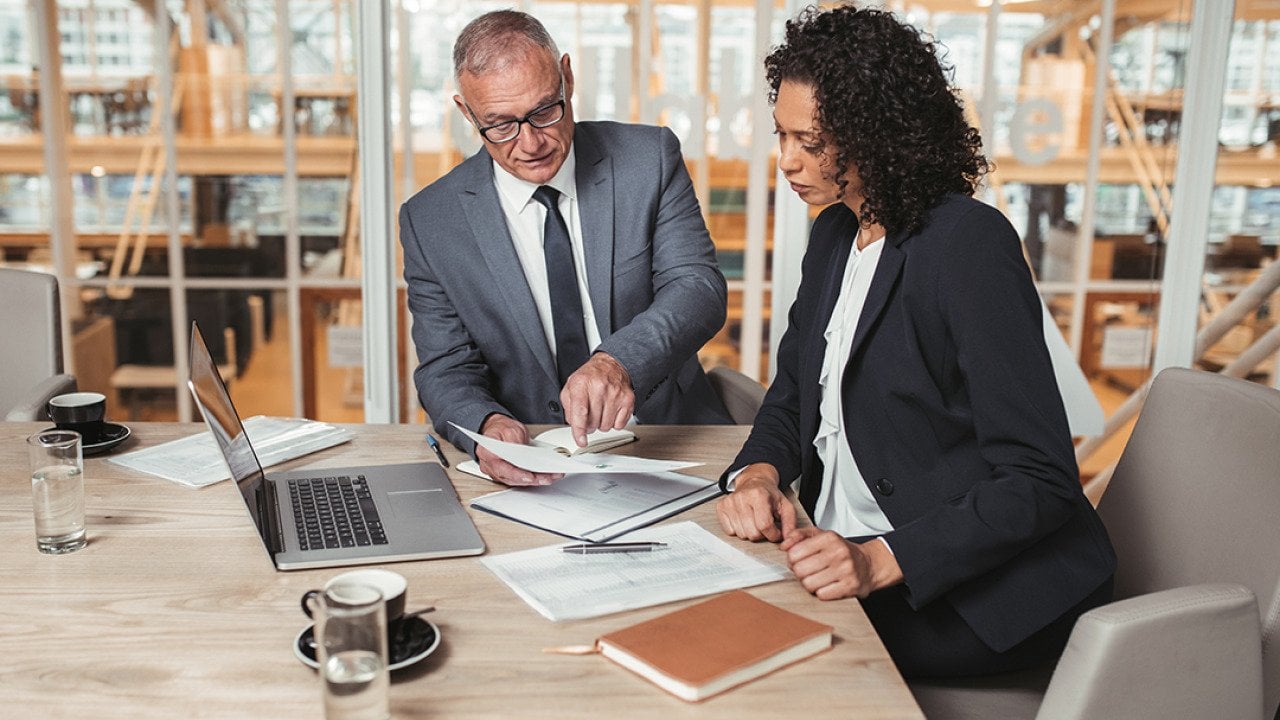 Two business executives reviewing a report.