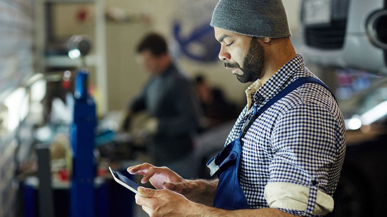 A mechanic using a tablet to process an order.