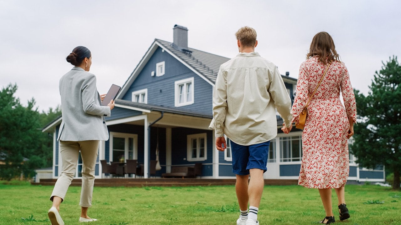 A young couple viewing a property for sale with an agent.