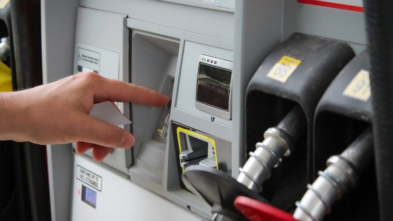 Person entering numbers on a fuel pump station keypad.
