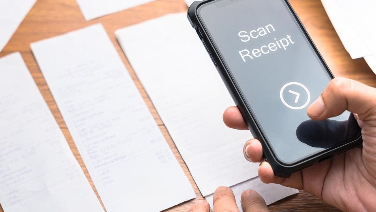 A person scanning paper receipts from a smartphone.
