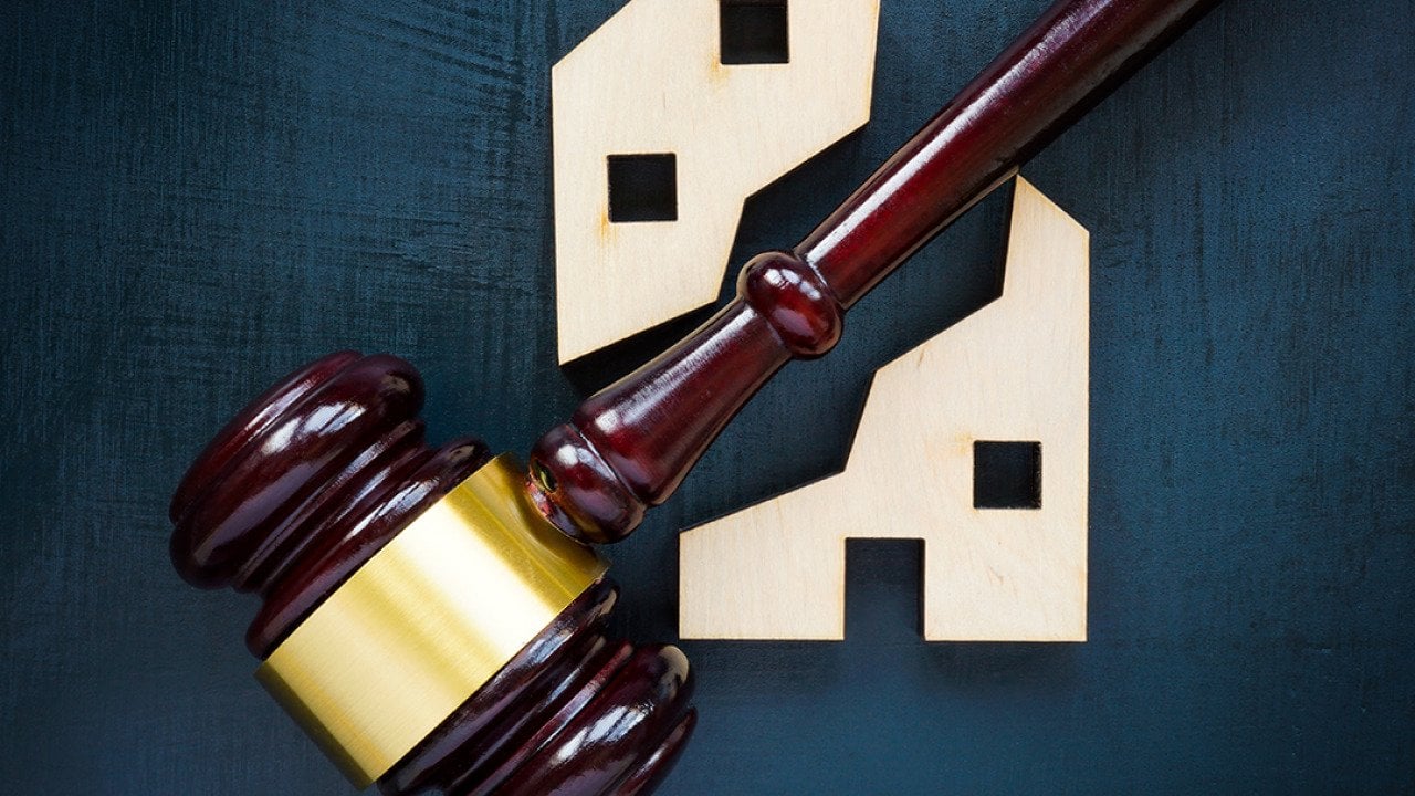 A wood house block separated by a gavel into two parts.