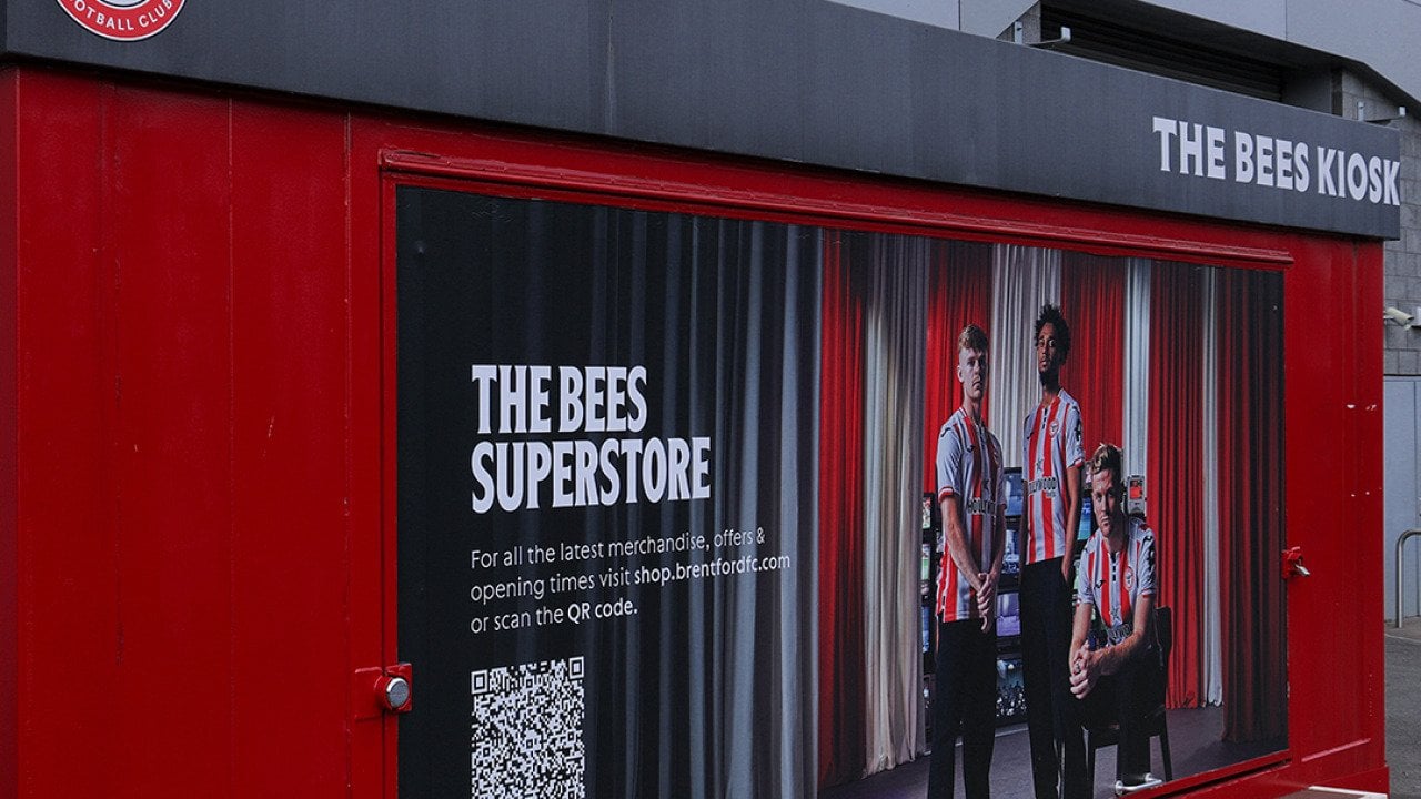 A Brentford Football Club merchandise kiosk promoting The Bees superstore with a QR code in London, United Kingdom.