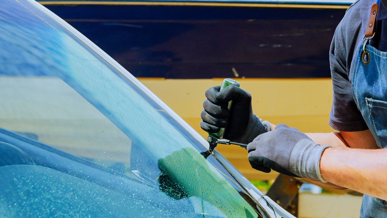 A technician replaces a damaged windshield at a car service center.