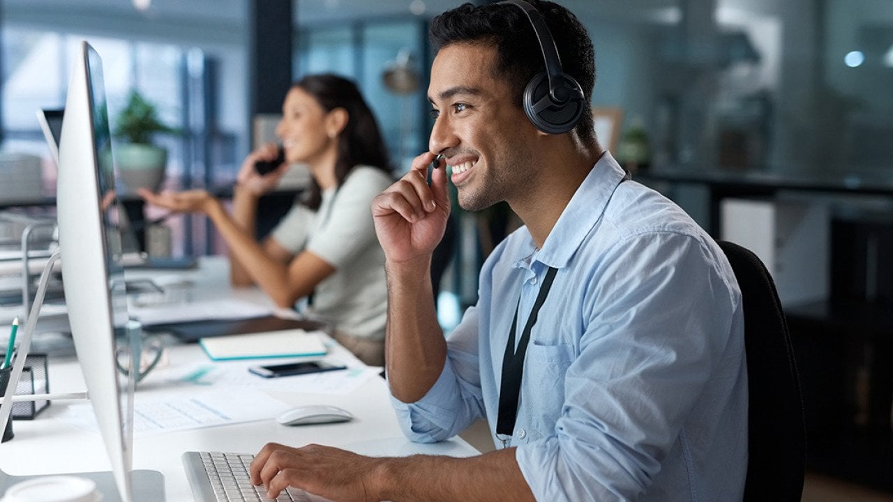 A happy male customer service representative in a call.