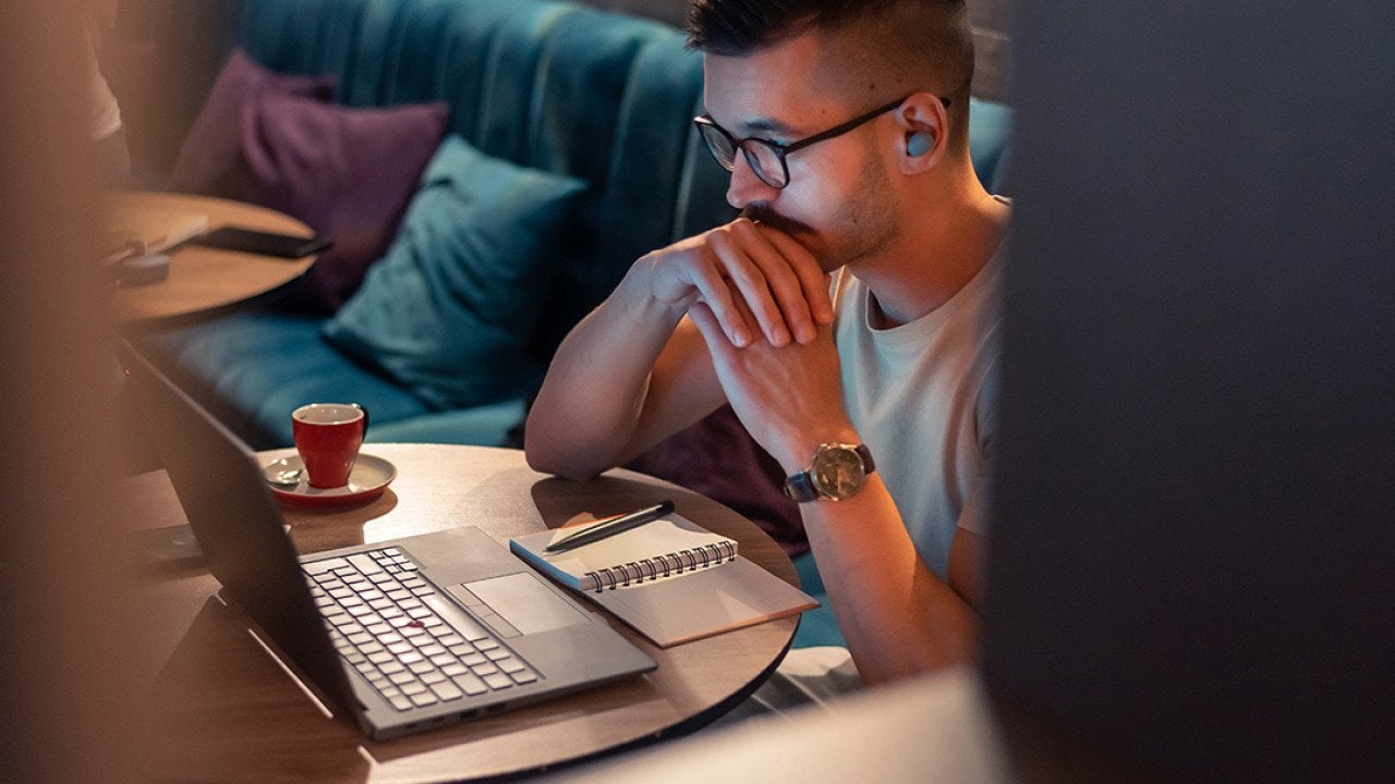A focused male professional working from a cafe.