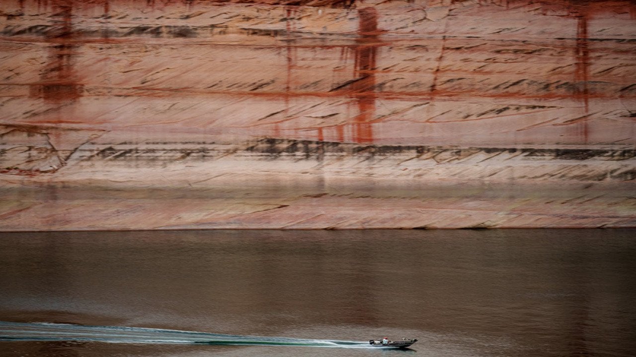 A powerboat cuts through the water on Lake Powell near Glen Canyon Dam in Page, Arizona.