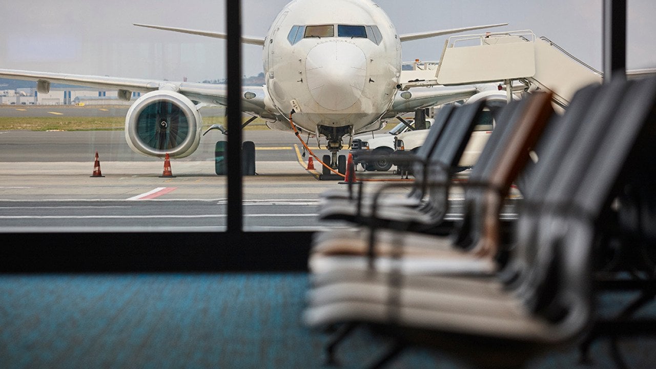 A view of a plane being refueled from the departure area of an airport.