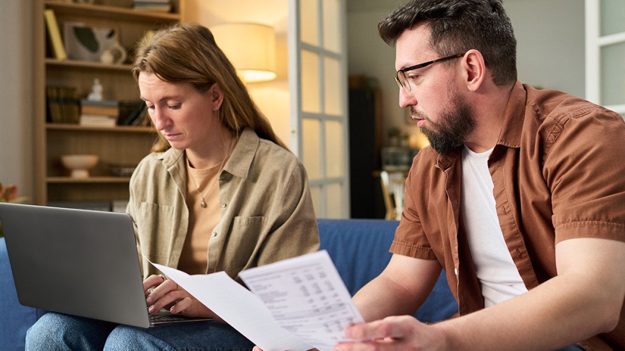 Couple at home organizing tax documents.