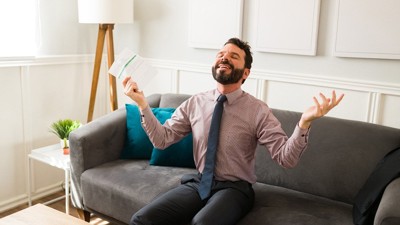 A businessman feeling free and happy while holding financial document.