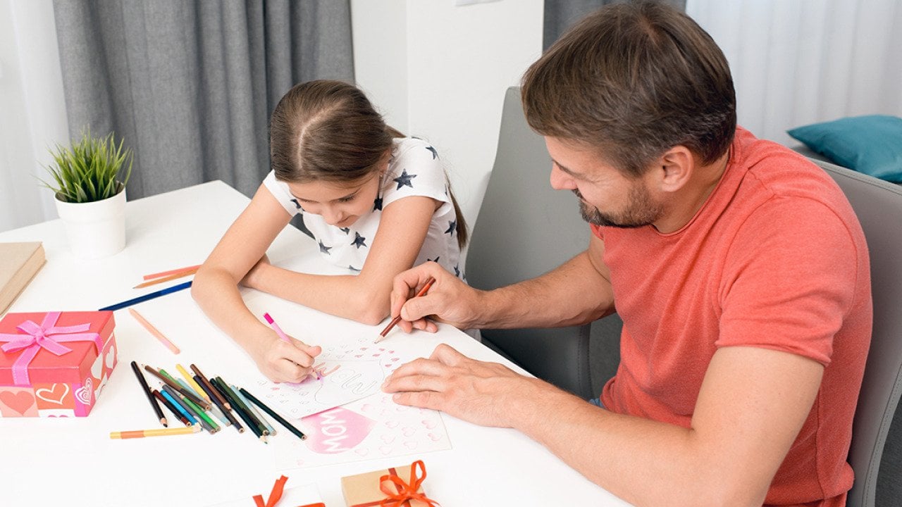 A father and daughter do arts and crafts for Mother's Day.