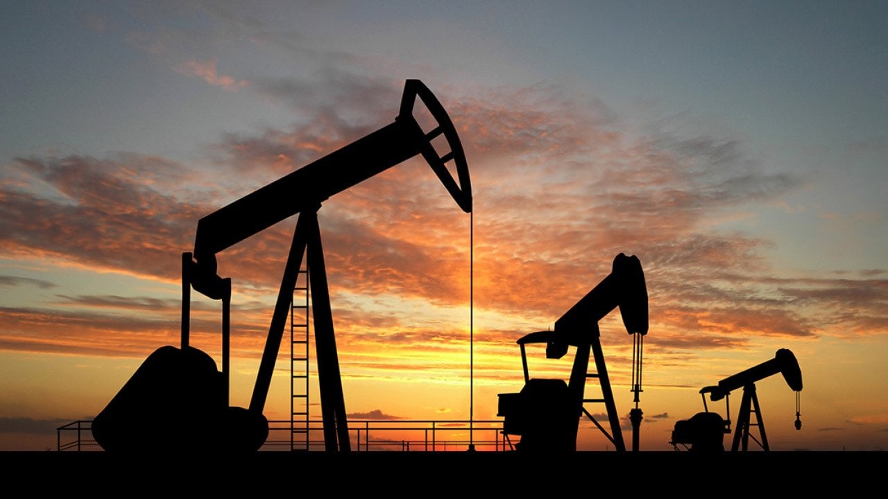 Silhouette of gas pumps machinery during sunset.