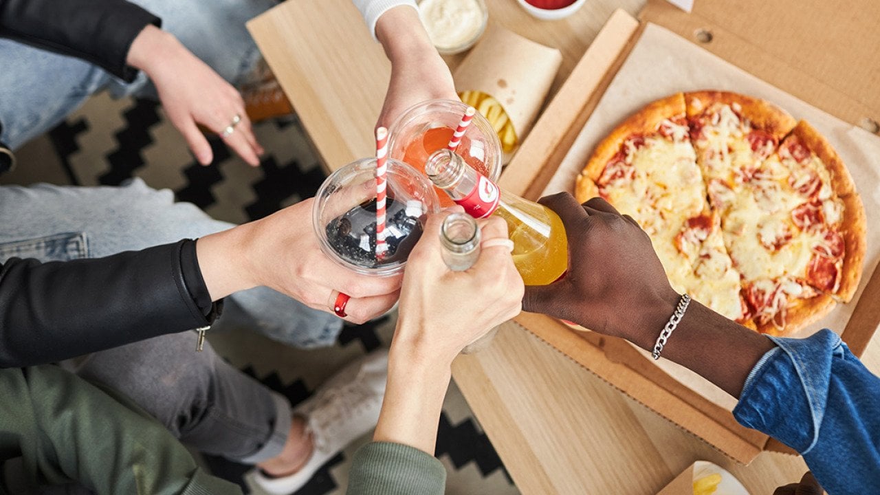 People raising their glass beverages while celebrating at home.