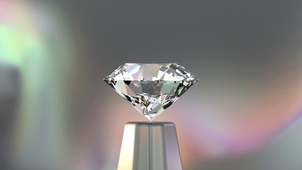 A 3D rendering of a round diamond with an iridescent backdrop.