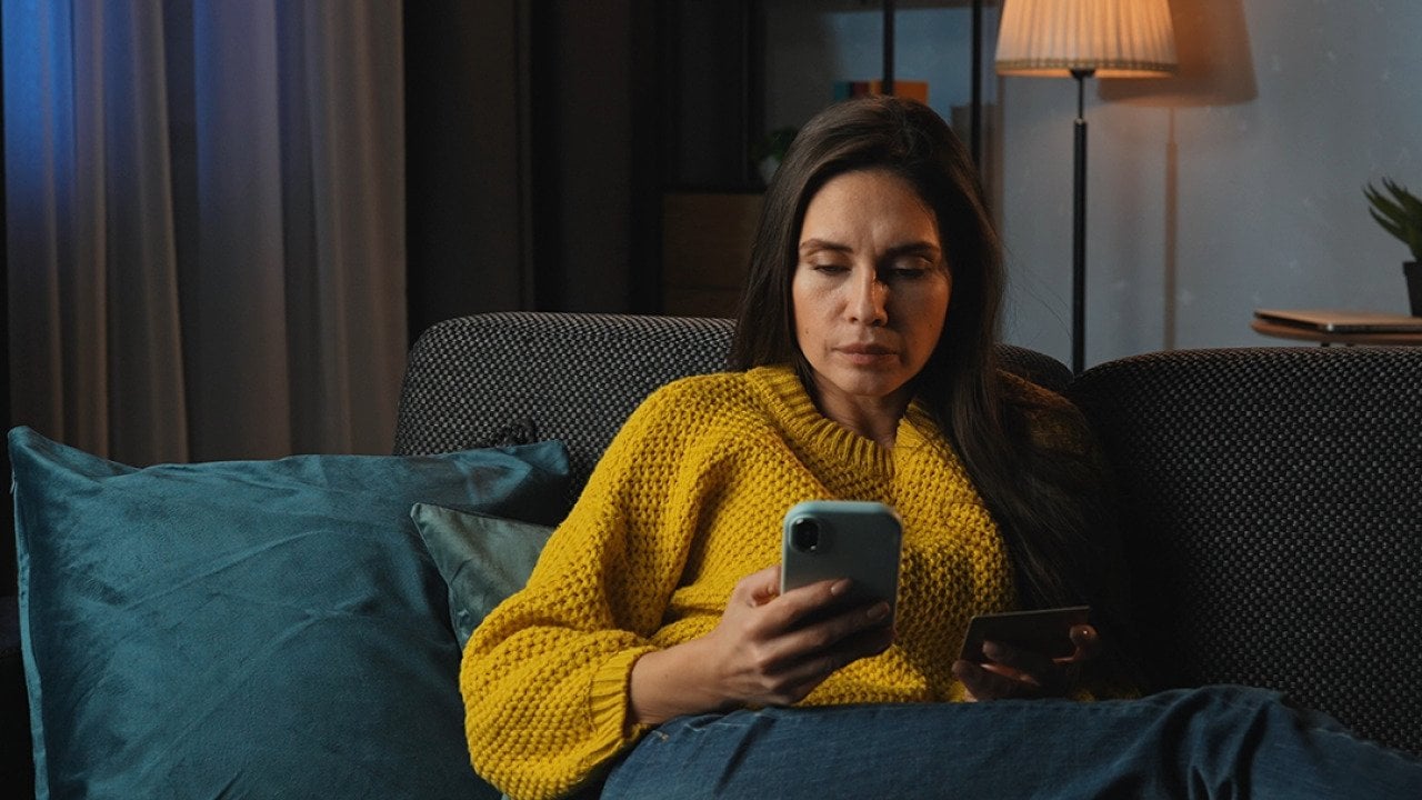 A middle-aged woman at home purchasing online using her credit card.