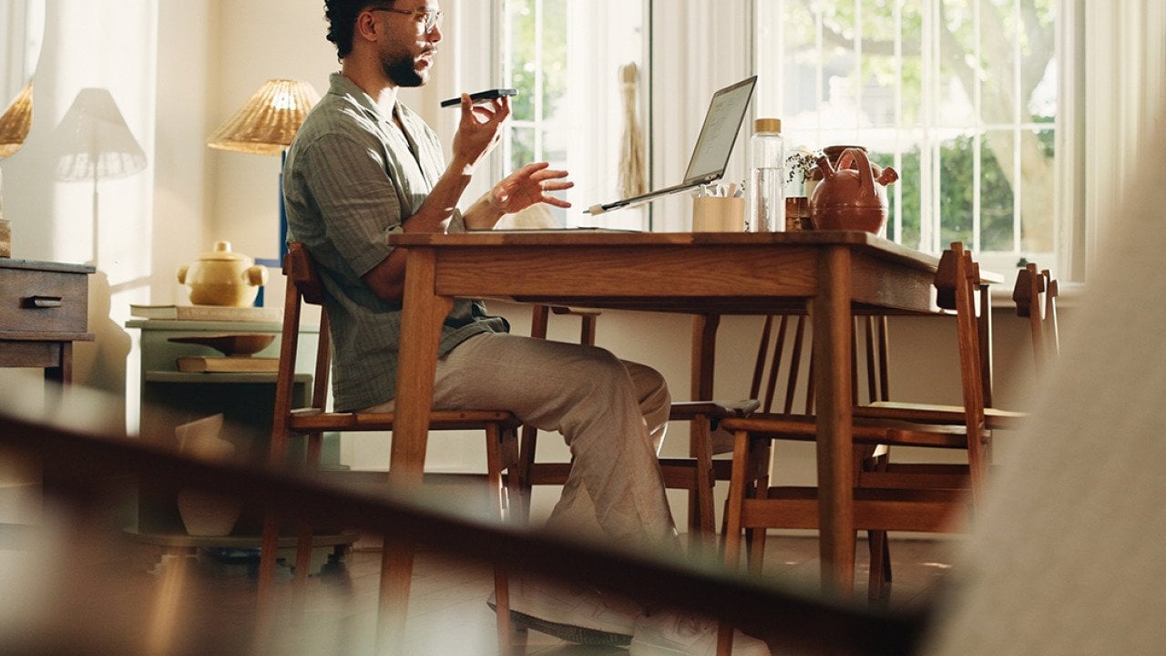 A businessman working from home and talking on the phone.