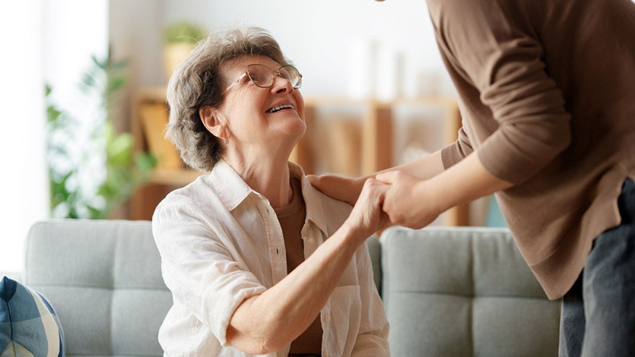 An elderly patient with her caregiver sharing a conversation with each other.