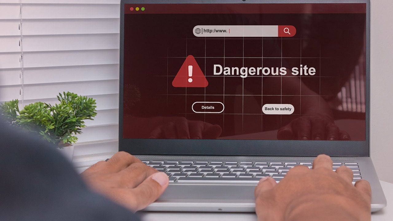 A dangerous site warning displayed on a laptop.