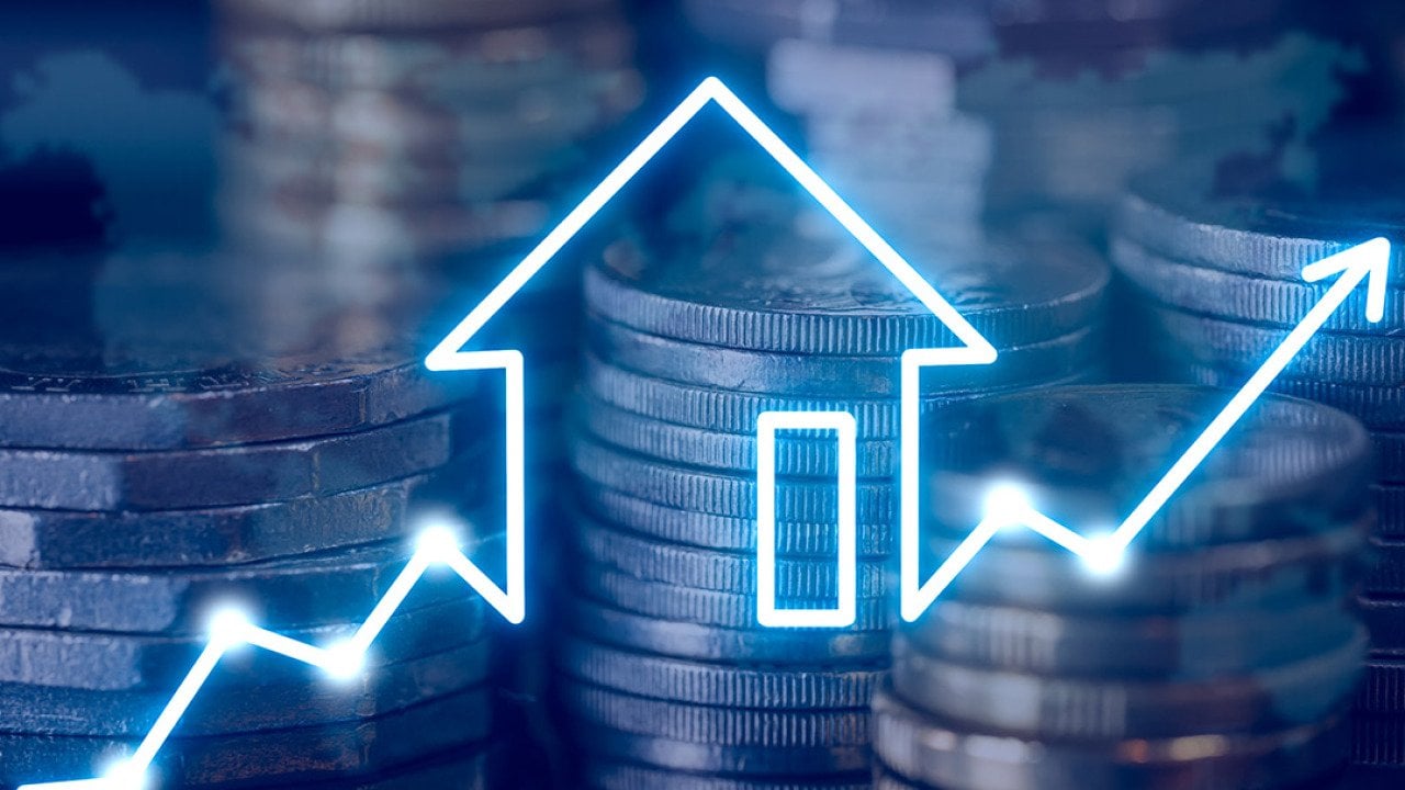 Stacks of coins with a house icon and an arrow pointing upward to the right.