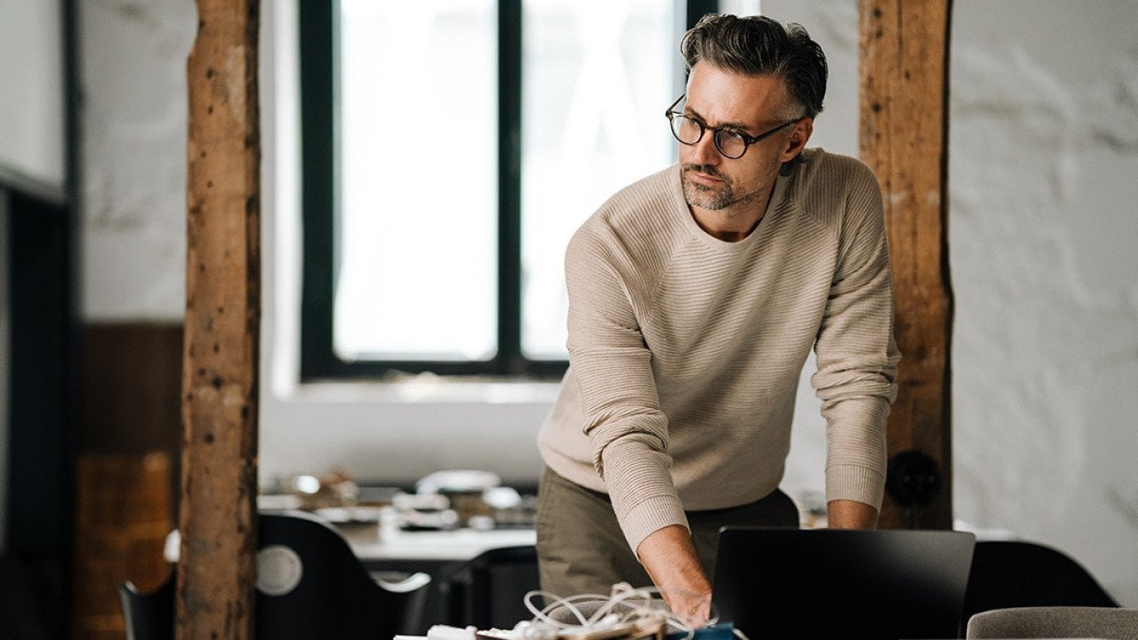 A businessman working from his laptop in an office.