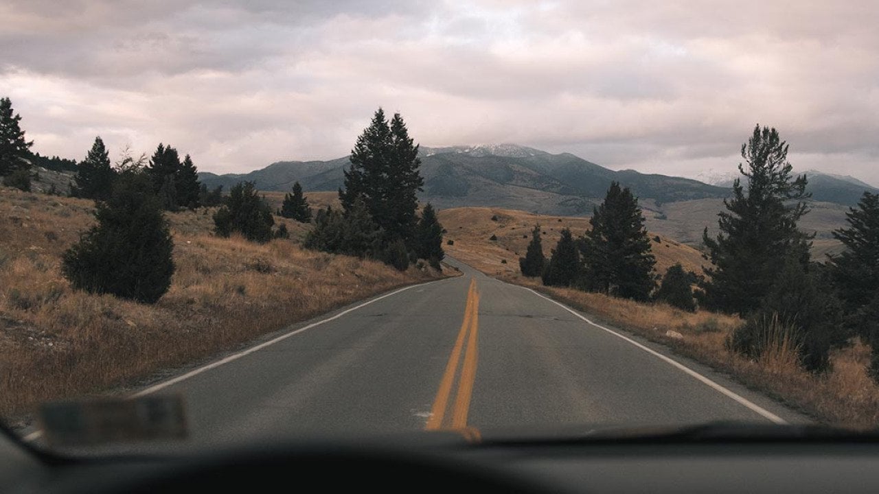 A scenic highway with a mountainous terrain in the distance.