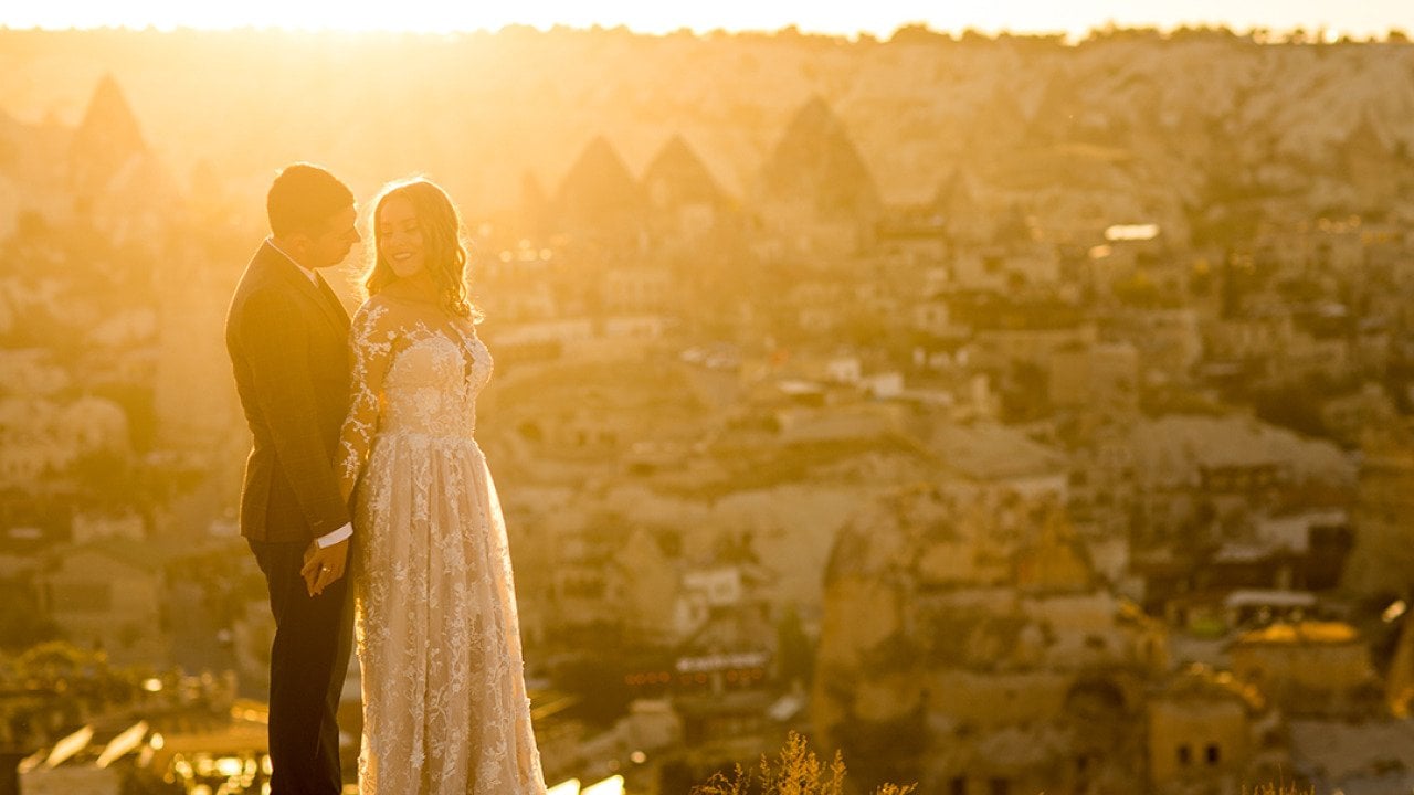 A couple poses for a sunset wedding photograph in their venue in Cappadocia, Turkey.