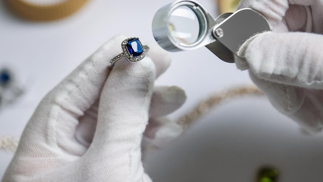 An appraiser inspecting a blue diamond ring.