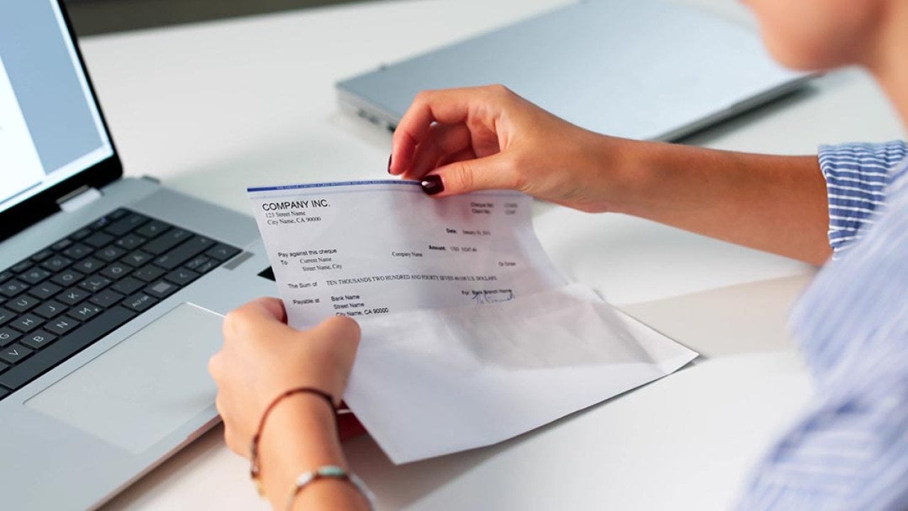 A payroll officer reviewing a compensation check.