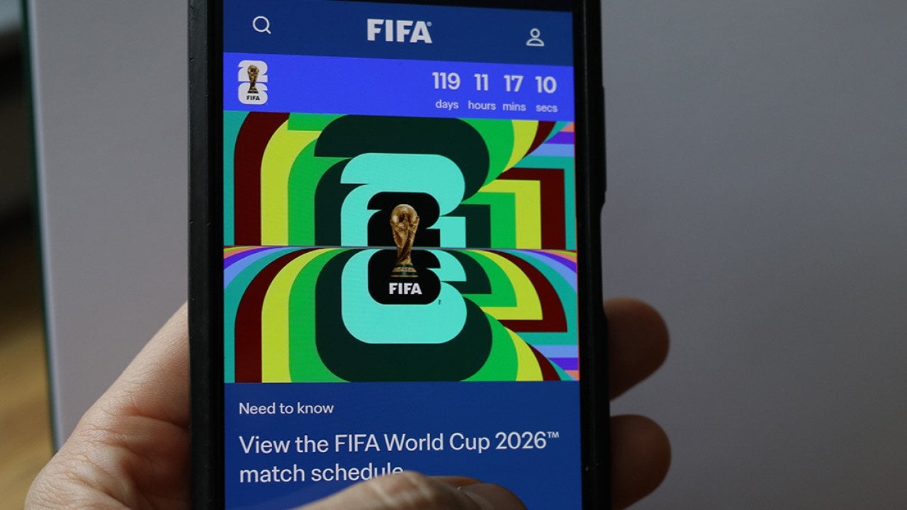 Person scrolling through a FIFA World Cup 2026 news article on a phone.