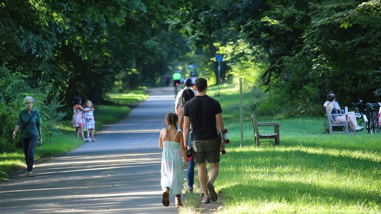 People walking and sitting along Minuteman Bikeway, Massachusetts, USA.