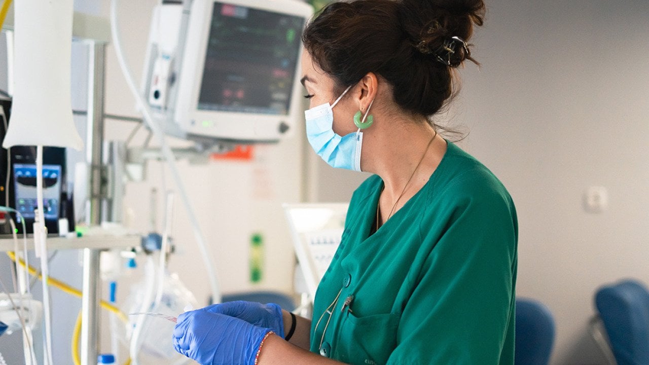 An ICU nurse working with medical monitors.