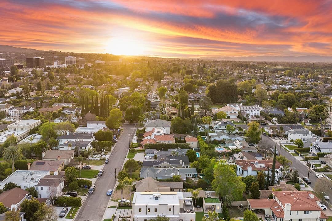 Aerial view of a suburban neighborhood at sunset.