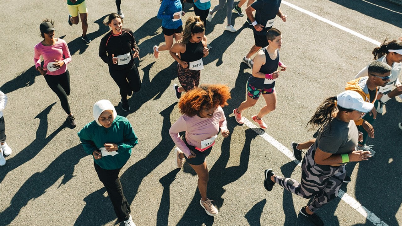 Aerial view of a diverse group of participants running in an organized outdoor race.