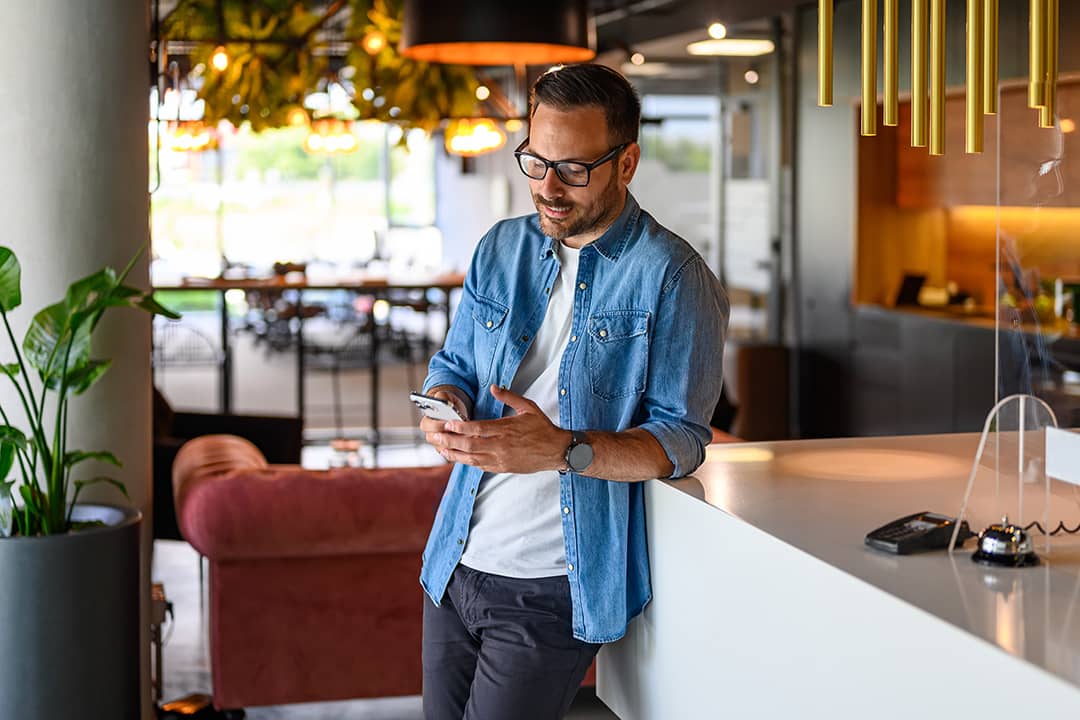 A businessman checking social media from his smartphone for their business' marketing.