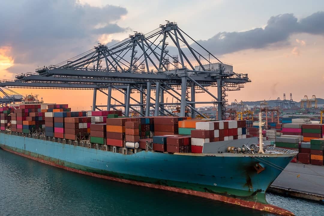 A commercial cargo ship at a terminal seaport.
