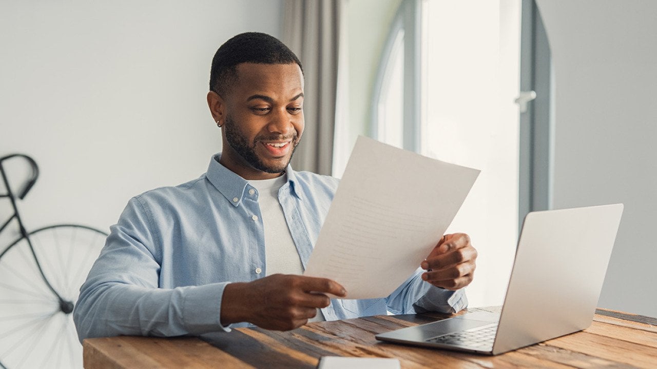 A young adult reading an important letter of his personal achievement at work.
