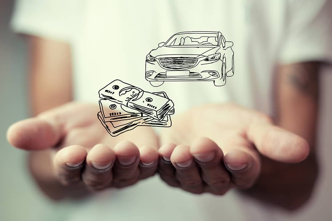 Person holding over an illustration of cars and money as a concept of insurance.