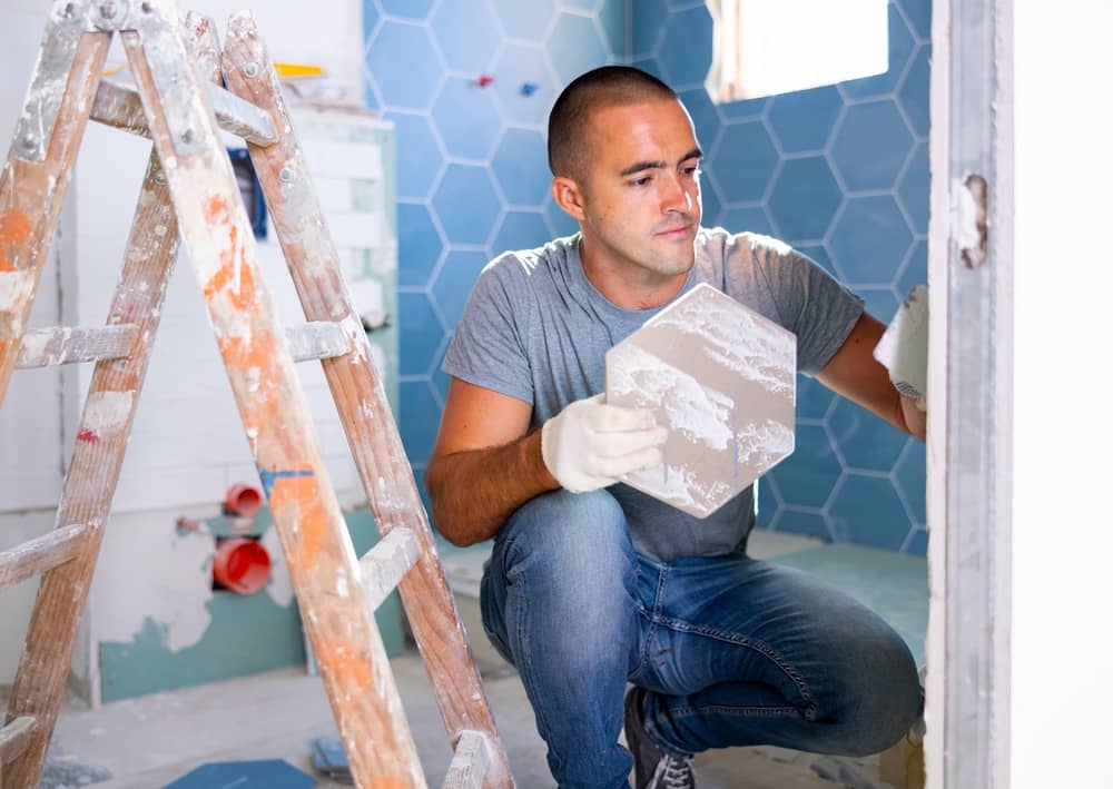 Man installing bathroom tile.