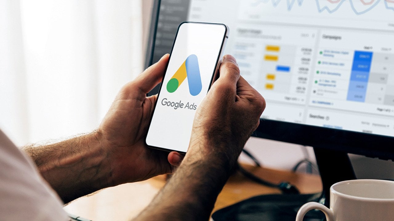 Man using a mobile phone with Google Ads on the screen.